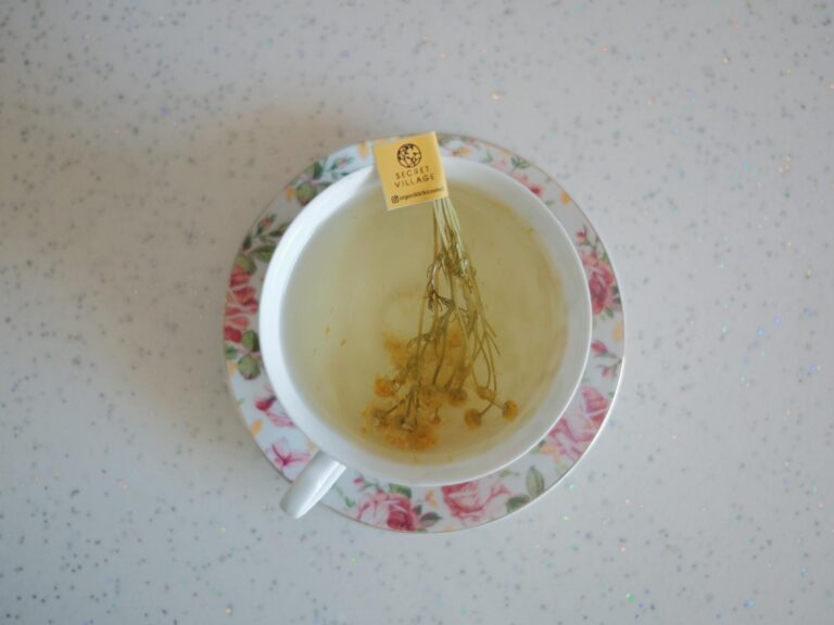 A close-up shot of chamomile tea in a floral teacup on a glittery table adds elegance and calm.